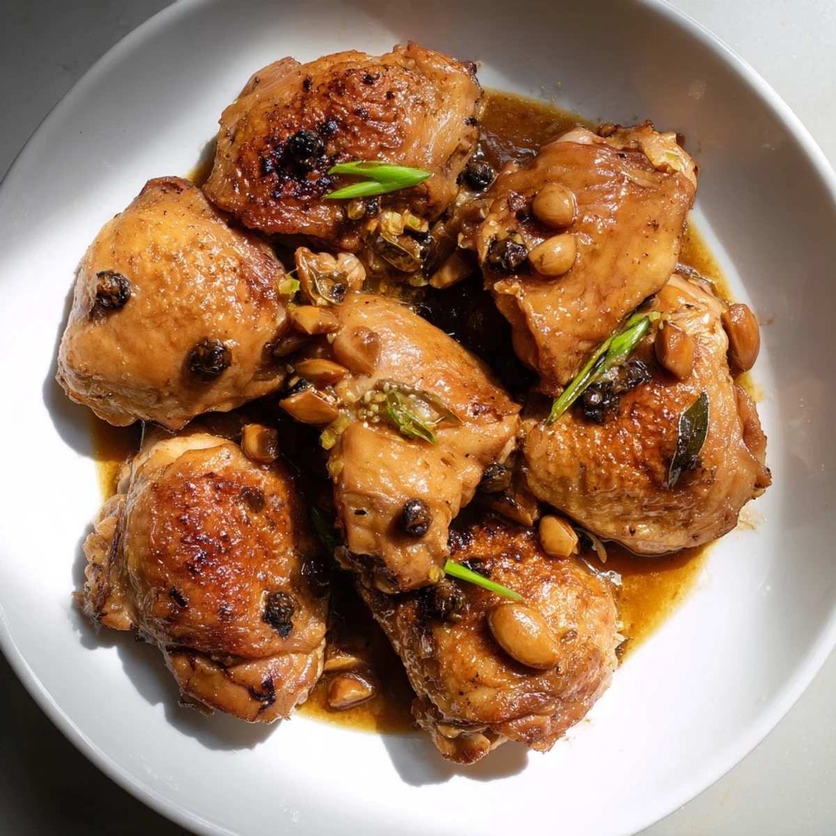 Tender Filipino Chicken Adobo with glistening skin, served generously over fluffy white rice.