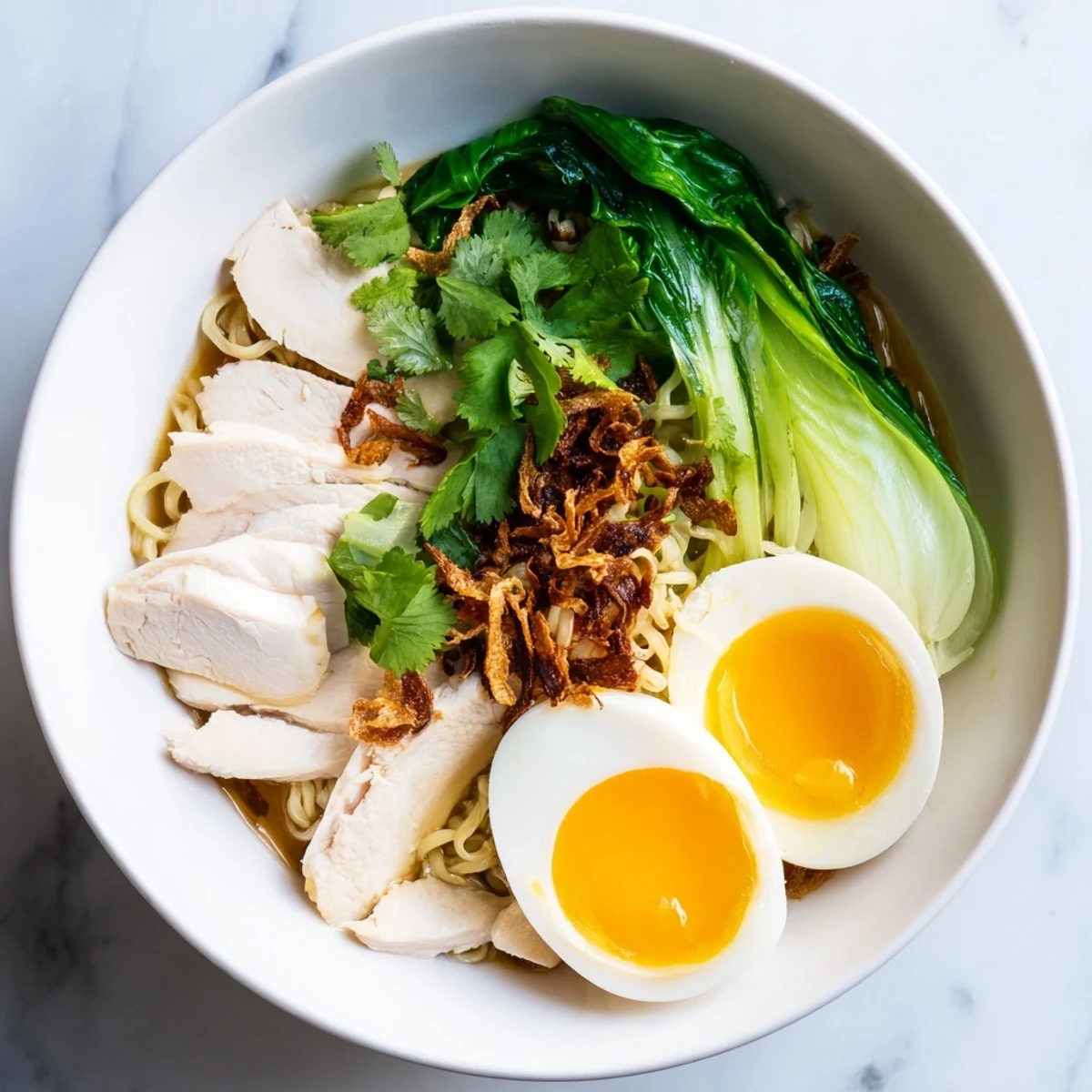Fragrant Thai Miso Ramen Bowl with shredded chicken, soft-boiled eggs, bok choy, and crispy shallots in a savory broth.
