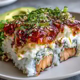 This comforting Spicy Salmon Sushi Bake features bubbling melted cheese and nori over a bed of seasoned rice.