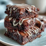 Baseball-themed brownie bites with white icing laces on a dessert platter, perfect for game day or sports parties.