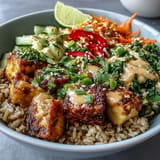Crispy oven-baked tofu over brown rice, a delicious vegan meal option.