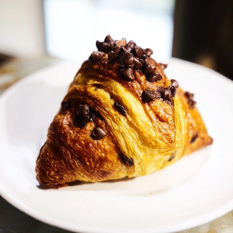 Warm, golden-brown Viral Crookies with gooey chocolate chips, ready to devour on a plate.
