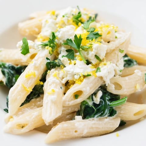Creamy Feta Spinach Pasta twirled on a fork, coated in a velvety tangy sauce with wilted greens.