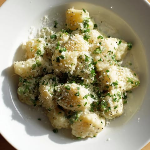 Golden-hued Creamy Parmesan Orzo with Green Peas, ready to serve with a light, velvety sauce.