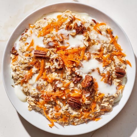 This Carrot Cake Overnight Oats recipe shows off a layered jar of creamy, spiced oats and grated carrots.