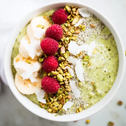 A close-up of vibrant green Matcha Overnight Oats, chilled and ready to eat with toppings.