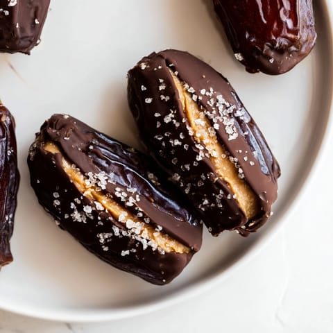 Homemade Chocolate Peanut Butter Dates, a delightful no-bake dessert sprinkled with sea salt flakes.