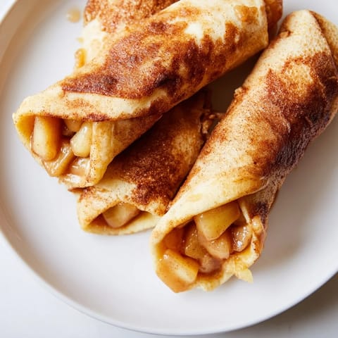 Warm, cinnamon-spiced Apple Pie Roll-Ups with a crispy exterior, perfect for a cozy dessert.