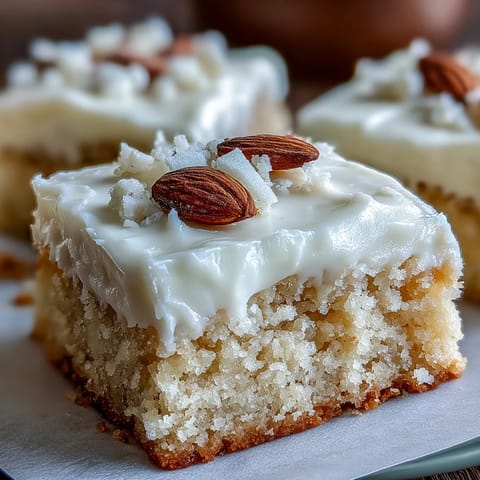 Golden-baked Almond Flour Sugar Cookie Bars cut into squares, showcasing soft, chewy texture topped with velvety frosting.