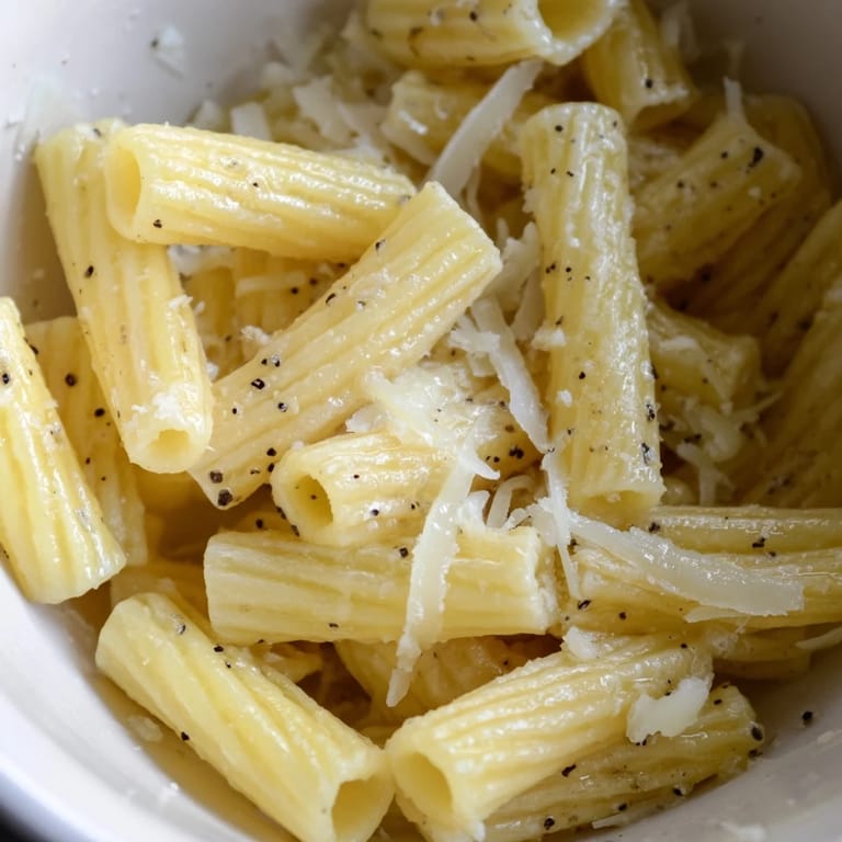 Hearty microwave pasta dish topped with black pepper and Parmesan, served alone for a quick vegetarian dinner.
