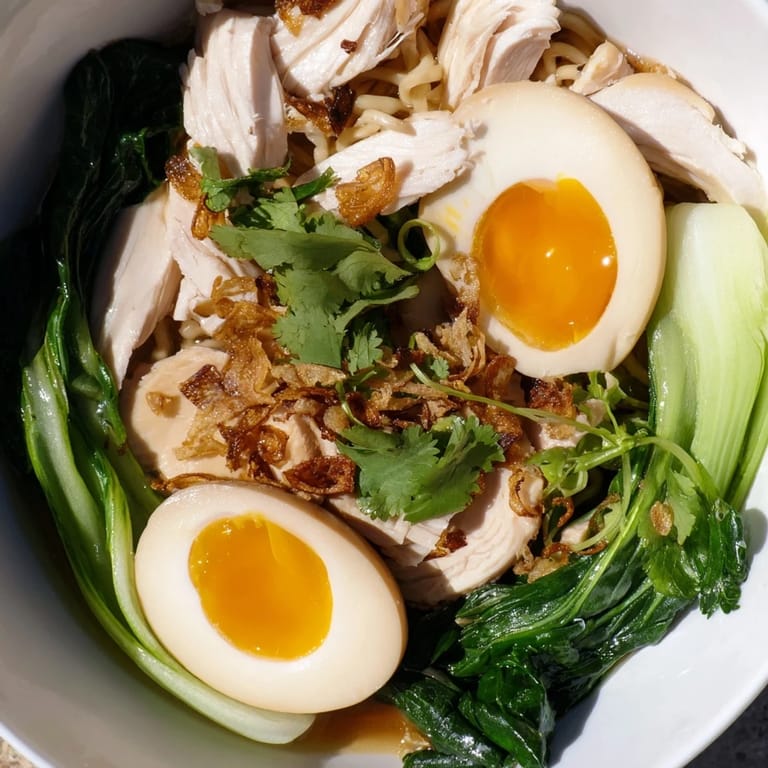 Hearty Thai Miso Ramen Bowl topped with tender chicken, jammy eggs, fresh cilantro, and a squeeze of lime for brightness.