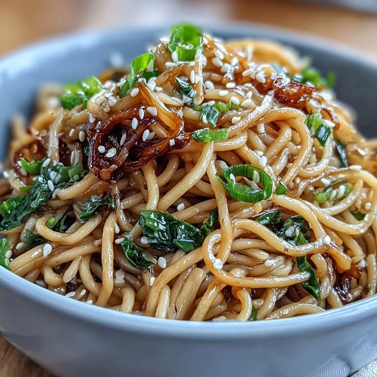 Asian Ginger Scallion Noodles with Soy Glaze - Vibrant noodles tossed with aromatic ginger, scallions, and a rich umami soy glaze, garnished with toasted sesame seeds for added crunch.