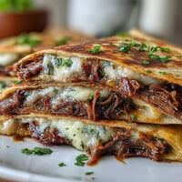 Golden, crispy Cinco de Mayo Birria Quesadillas with dipping consommé.