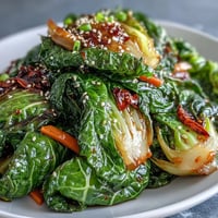 Vibrant Spicy Cabbage Stir Fry, crisp carrots, chili flecks, and sesame seeds garnish.